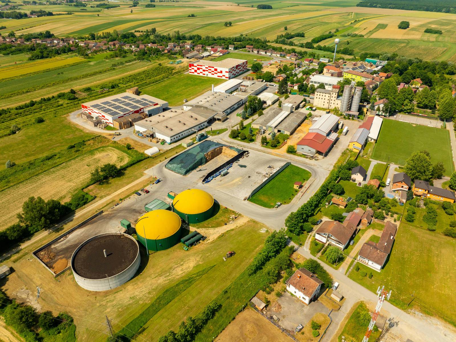 Aerial view of a biogas plant with anaerobic digesters and feedstock storage